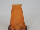 an orange glass vase sitting on top of a white surface