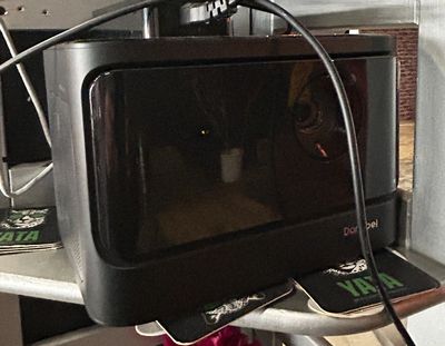 a microwave sitting on top of a shelf with a flower in it