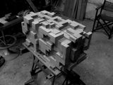black and white photograph of a pile of wooden blocks on a workbench