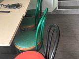 quatre chaises disposées autour d'une table dans une petite pièce