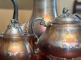 three silver teapots sitting on a table next to each other