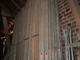 a pile of metal pipes in a room with a brick wall