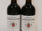 two bottles of red wine sitting next to each other on a table