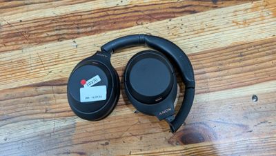the headphones are sitting on a wooden table with a price tag