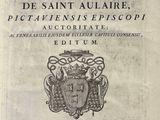an old book with a picture of a coat of arms on it