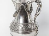 a silver coffee pot with a handle on a white background