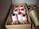 many spools of thread in a box on the floor