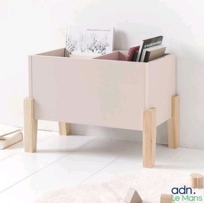 a wooden toy box with books in it on a white floor