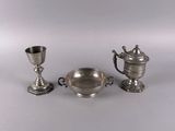 three pieces of silverware including a cup, saucer, and spoon