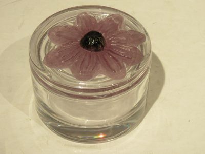un petit bocal en verre contenant une fleur