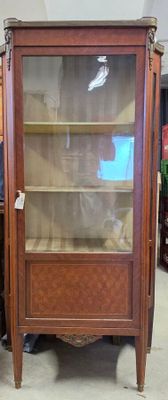 une vitrine avec une porte vitrée au milieu d'une pièce