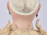 a doll that is wearing a shirt and earrings