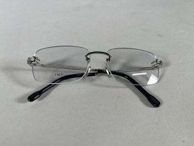 une paire de lunettes posée sur une table, sur fond blanc
