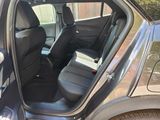 a black car with the door open sitting in a parking lot