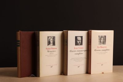 Trois livres sont alignés sur une table devant un fond noir.