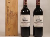 deux bouteilles de vin rouge et une boîte en bois posées sur une table
