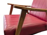 a red leather chair with a wooden frame and arm rest