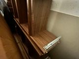 une étagère en bois sur laquelle sont posés tout un tas de livres