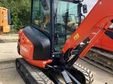 the back end of a small excavator is parked on the side of the road