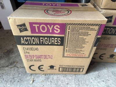Des cartons de jouets sont empilés les uns sur les autres par terre.