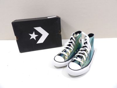 des chaussures Converse avec leur boîte et une paire de Converse posée sur une table