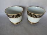 pair of white and gold cups with greek design on them