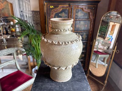 a large vase sitting on top of a table next to a mirror