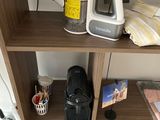 a shelf that has a coffee maker and other items on it