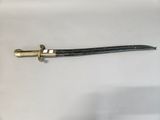 a close up of a sword on a white surface with a black handle