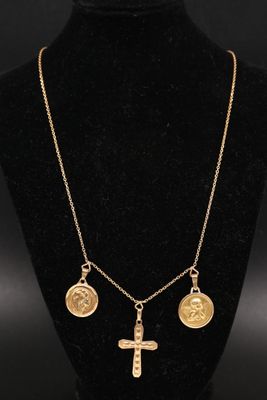 un collier en or orné d'une croix et de quatre pièces