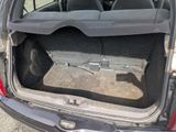 a cat sitting in the back of a car with its trunk open