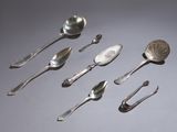 Plusieurs cuillères en argent et cuillères-cuillères sont alignées en rangée