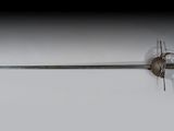 une épée en métal dont la lame métallique se détache sur un fond blanc