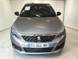 the front of a silver car in a garage with a number plate on the front of the car