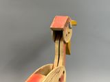 a wooden toy bird that is sitting on a table