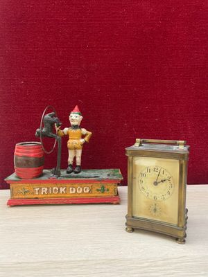 a small clock sitting next to a small figurine of a fireman