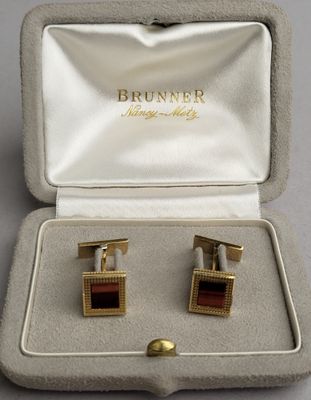 deux paires de boutons de manchette dorés et rouges dans un coffret