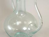 a clear glass vase with an elephant handle on it