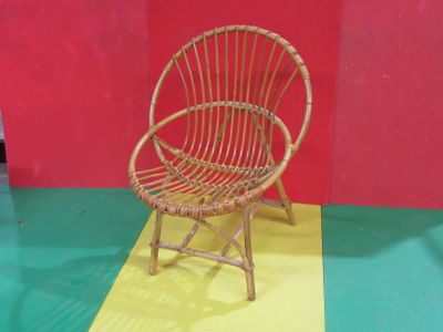 une chaise en osier posée sur un sol jaune et rouge