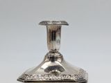 an antique silver plated candle holder on a white background