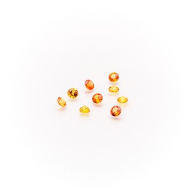 a group of yellow and orange gems on a white surface