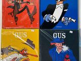 four books of comics are sitting on a white surface