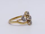 a close up of a gold and diamond ring on a white surface