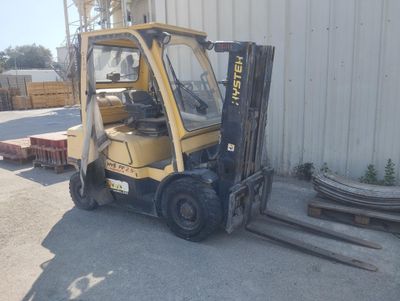 a yellow forklift truck parked in front of a building