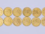 a close up of a row of gold coins on a white surface