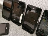 several cell phones are sitting on a table with a broken screen
