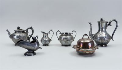cinq théières en argent et un bol en argent posés sur une table