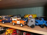 de nombreux camions miniatures posés sur une étagère dans une pièce