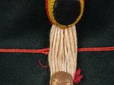 a green hat with a red and yellow button on it