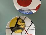 two plates with different designs on them hanging on the wall